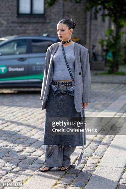 Livia Nunes Marques wears grey blazer, grey pants, body, grey denim skirt outside Ganni during the Copenhagen Fashion Week Spring/Summer 2024 on...
