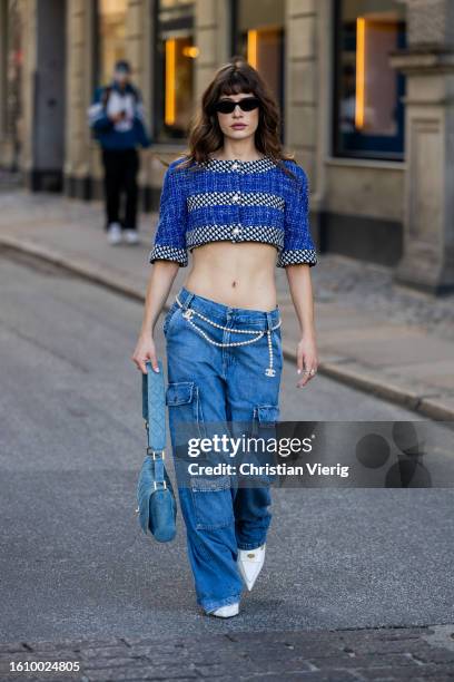 Lea Naumann wears cropped button up top, denim jeans with side pockets, Chanel bag outside Rotate during the Copenhagen Fashion Week Spring/Summer...