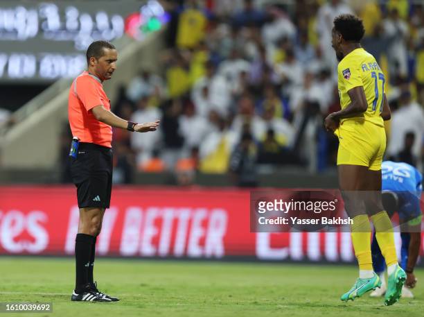Referee Redouane Jiyed speaks with Abdullah Al Khaibari of Al Nassr during the Arab Club Champions Cup Final between Al Hilal and Al Nassr at King...