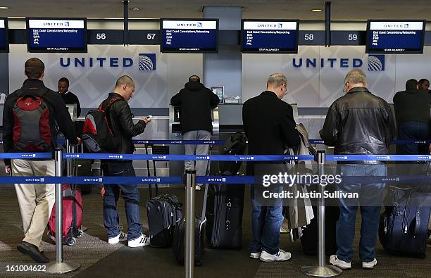 United Airlines passengers line up to rebook flights that were canceled due to weather on February 8, 2013 in San Francisco, California. Thousands of...