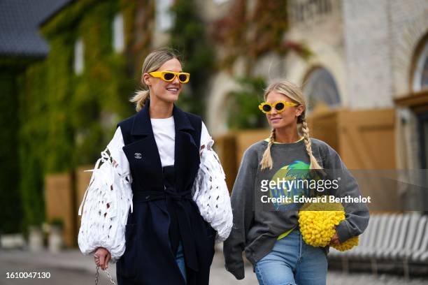 Guest wears yellow squared sunglasses, a white cut-out pattern puffy long sleeves blouse, a navy blue belted wool / sleeveless long coat from Chanel,...