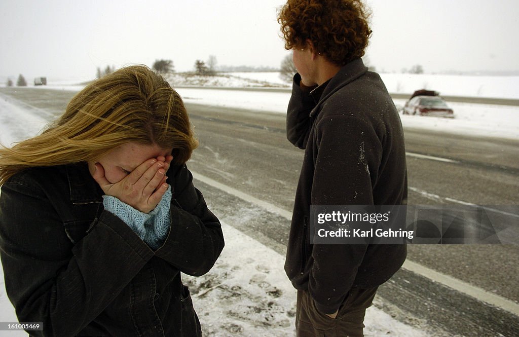 IOWA CITY, IOWA (12-08-05) -- Driver Kim Lemke, left, was overcome with emotion after crashing into a semi-truck and losing control of her car on Interstate 80 near Iowa City, Iowa. Her friend Mathew Greenwood, center, used a cell-phone to call 911 to rep