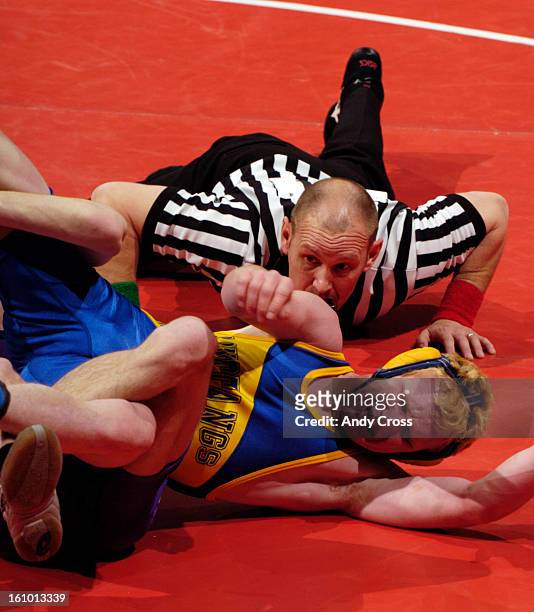 Wrestling official, Blair Lampe, <cq> keeps a careful eye on Pecas McClellan, Nucla, as he gets wrapped up by Jordan Davison, <cq> Wray, in the 2A...