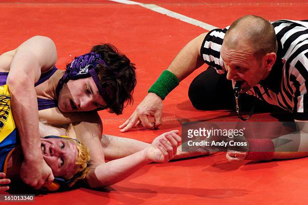 Wrestling official, Blair Lampe, <cq> keeps a careful eye on Pecas McClellan, Nucla, bottom, as he gets wrapped up by Jordan Davison, <cq> Wray, in...