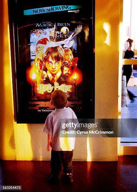 Year old Christian Robb of Centennial, Colorado stares up at the movie poster announcing Harry Potter and Sorcerer's Stone is now showing at United...