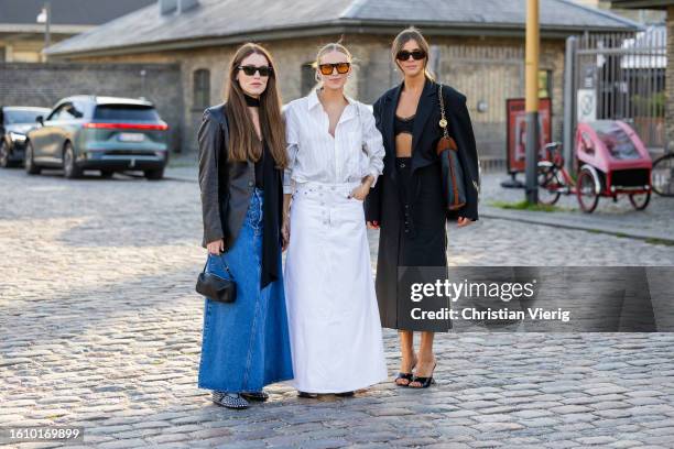 Annabel Rosendahl wears denim skirt, black blazer & Tine Andrea wears white striped button shirt skirt, bag & Darja Barannik wears Chanel bag, black...