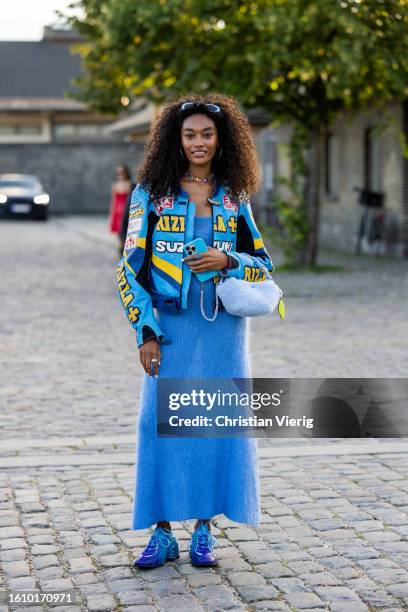 Cheyenne Maya Carty wears blue cashmere dress, jacket with print, bag, Nike sneaker outside Ganni during the Copenhagen Fashion Week Spring/Summer...