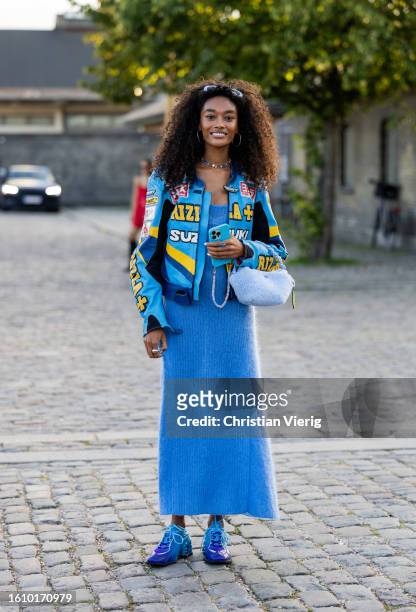 Cheyenne Maya Carty wears blue cashmere dress, jacket with print, bag, Nike sneaker outside Ganni during the Copenhagen Fashion Week Spring/Summer...
