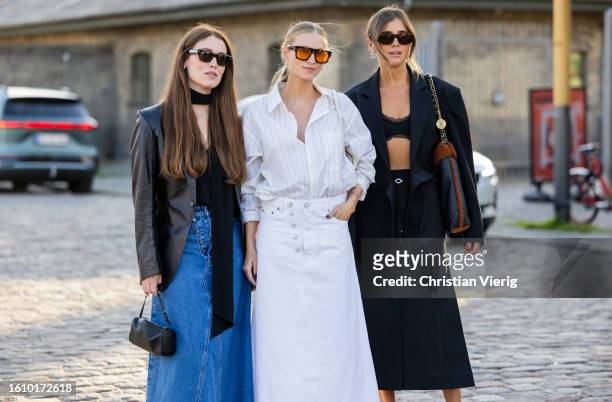 Annabel Rosendahl wears denim skirt, black blazer & Tine Andrea wears white striped button shirt skirt, bag & Darja Barannik wears Chanel bag, black...