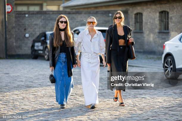 Annabel Rosendahl wears denim skirt, black blazer & Tine Andrea wears white striped button shirt skirt, bag & Darja Barannik wears Chanel bag, black...