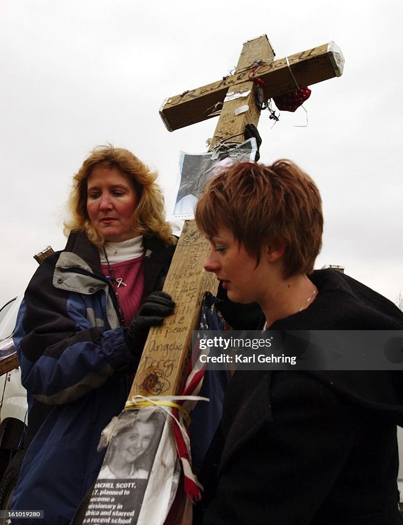 Rhonda Erdman, left, and Valerie Haile carried a cross into Clement Park where it was put on display on the third anniversary of the Columbine High School shooting rampage. The cross, one of thirteen made by Chicago carpenter Greg Zanis is dedicated to Ra