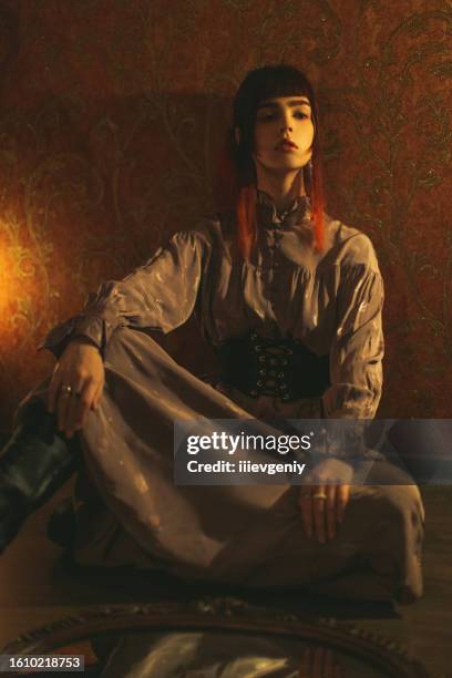 redhead gothic girl in dress with corset. candle light - vintage corset 個照片及圖片檔