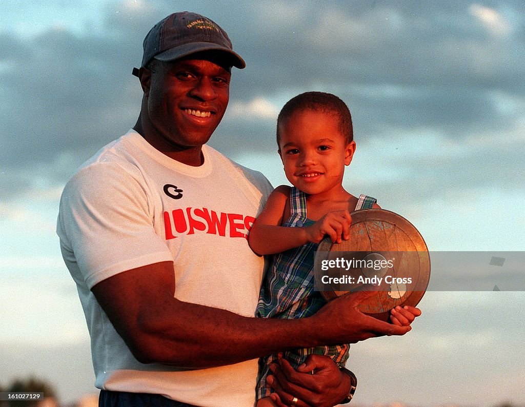 Discus thrower, Anthony Washington and his son Coleman, 2, at Overland High School last Friday afternoon. Washington was practicing for the upcoming World Championships. (Washington requested that the POST does NOT use his portrait for a poster, stating t