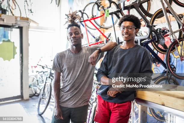 portrait of bike shop owners in their shop - gray shorts stock pictures, royalty-free photos & images