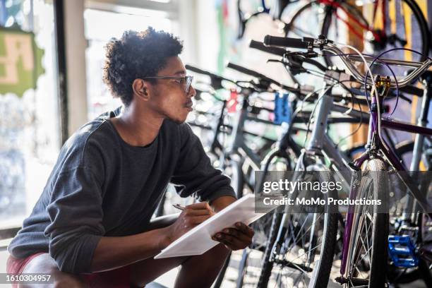 bike shop owner using clipboard to record inventory - gray shorts stock pictures, royalty-free photos & images