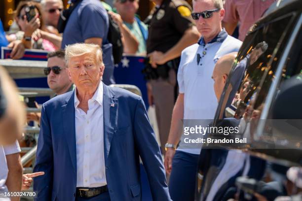 Republican presidential candidate and former U.S. President Donald Trump is directed to his vehicle after speaking at the Steer N' Stein bar at the...