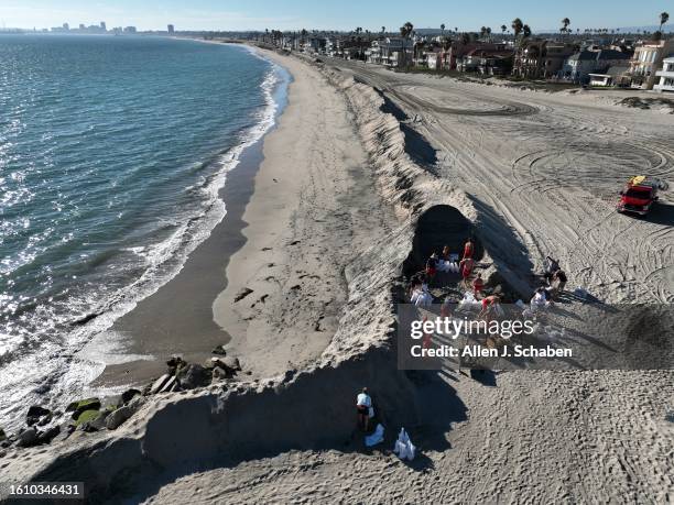 Long Beach, CA Long Beach lifeguards fill sand bags as residents pick them up to fortify their homes while crews build a sand berm along the shore of...