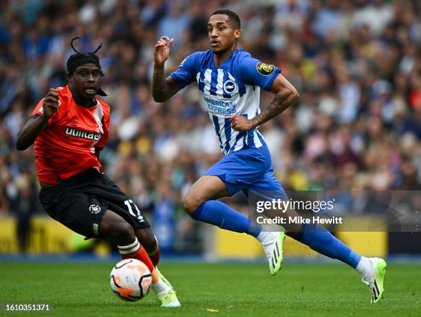 Joao Pedro of Brighton is challenged by Pelly Ruddock Mpanzu of Luto of Luton during the Premier League match between Brighton & Hove Albion and...