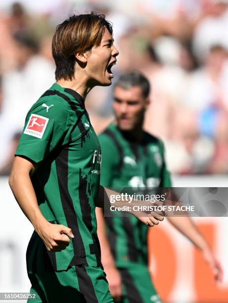 Moenchengladbach's Japanese defender Ko Itakura celebrates scoring the opening goal with his teammates during German first division Bundesliga...