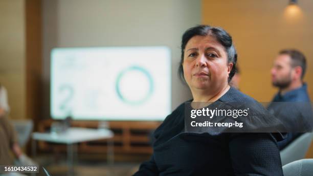 portrait of senior businesswoman during collaborative business meeting and presentation - pleased face laptop stock pictures, royalty-free photos & images