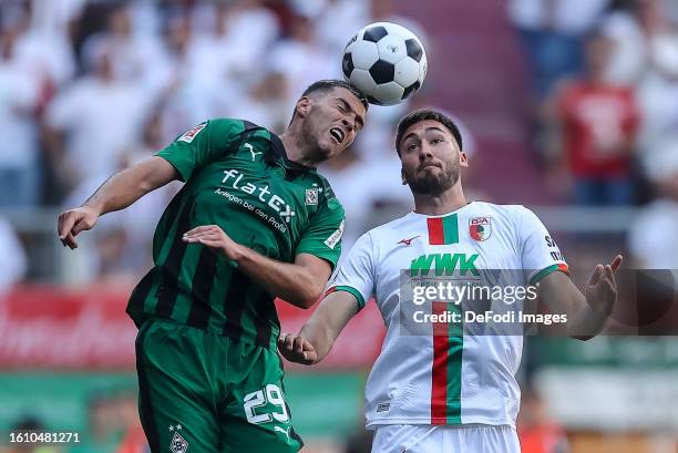 Joe Scally of Borussia Moenchengladbach and Dion Beljo of FC Augsburg battle for the ball during the Bundesliga match between FC Augsburg and...