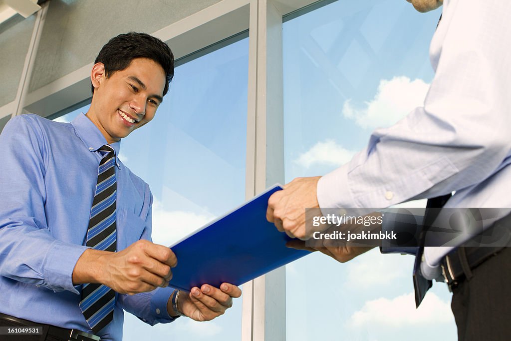 Asian business man handing over documents
