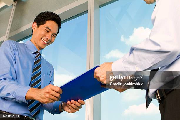 asian business man handing over documents - file sharing stock pictures, royalty-free photos & images