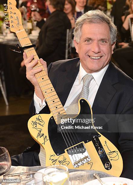 President and CEO Les Moonves poses with musician Bruce Springsteen's guitar during the auction at MusiCares Person Of The Year Honoring Bruce...