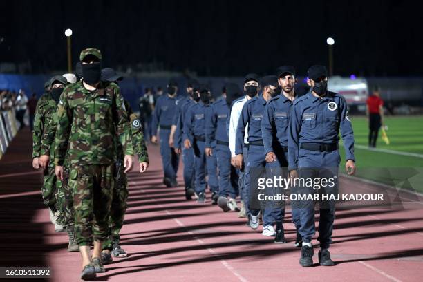 Security forces members deploy during the final match of a local football tournament at the municipal stadium in Syria's rebel-held city of Idlib, on...