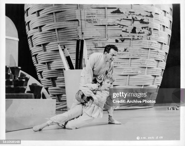 Cantinflas holds up Shirley Jones in a scene from the film 'Pepe', 1960.