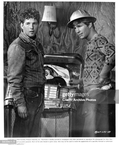 Timothy Bottoms and Jeff Bridges stand in front of a jukebox in a scene from the film 'The Last Picture Show', 1971.