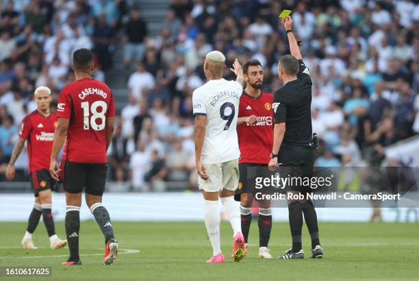 Manchester United's Bruno Fernandes is shown a yellow card by referee Michael Oliver during the Premier League match between Tottenham Hotspur and...
