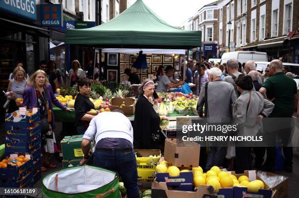 People browse stalls at Portobello Road Market in west London on August 19, 2023.