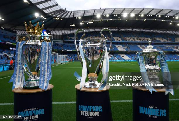 General view of the Premier League trophy, the Champions League trophy and the Emirates FA Cup trophy won by Manchester City last season on pedestals...