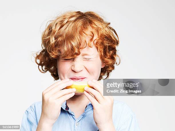 boy eating lemon - sour taste bildbanksfoton och bilder