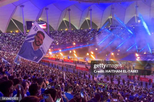Fan waves a flag bearing the image of Brazil's forward Neymar during his unveling at at Al-Hilal in Riyadh's King Fahd International Stadium on...