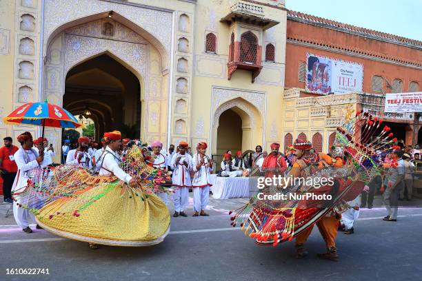 Rajasthani folk artists perform during a traditional procession on the occasion of 'Teej' festival, in Jaipur, Rajasthan, India, on Saturday, Aug 19,...