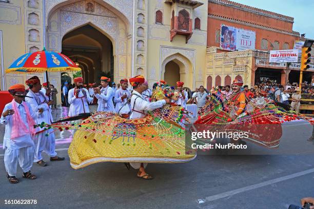 Rajasthani folk artists perform during a traditional procession on the occasion of 'Teej' festival, in Jaipur, Rajasthan, India, on Saturday, Aug 19,...