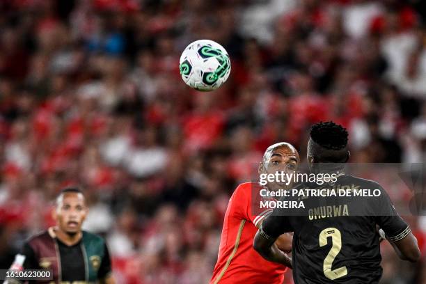 Benfica's Portuguese midfielder Joao Mario vies for a header with Estrela da Amadora's Kenyan defender Johnstone Omurwa during the Portuguese league...