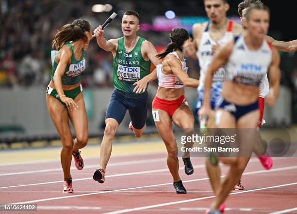 Budapest , Hungary - 19 August 2023; Chris O'Donnell of Ireland, passes the baton to Sharlene Mawdsley while competing in the mixed 4x400m relay...