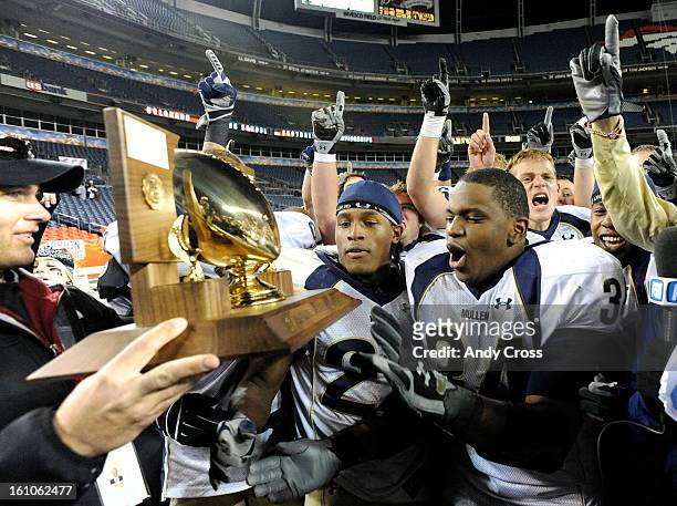 Adonis Ameen-Moore, #34, receives the 5A Championship trophy after defeating Cherry Creek in the 5A State Football Championship game at Invesco Field...