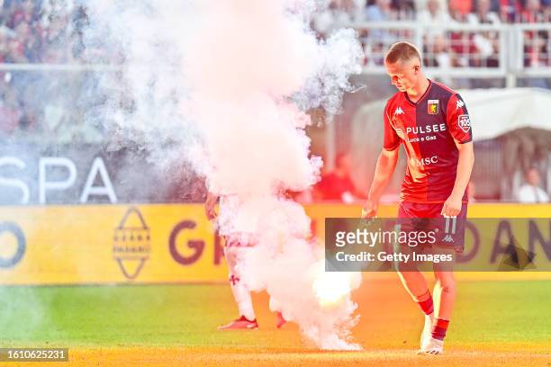 Albert Gudmundsson of Genoa collects a flare thrown onto the pitch during the Serie A TIM match between Genoa CFC and ACF Fiorentina at Stadio Luigi...