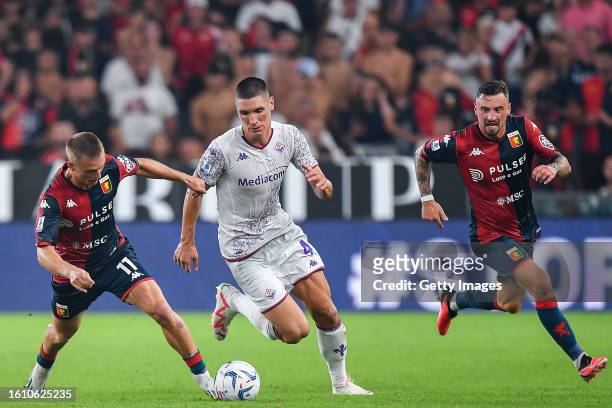 Nikola Milenkovic of Fiorentina is seen in action between Albert Gudmundsson and Filip Jagiello of Genoa during the Serie A TIM match between Genoa...