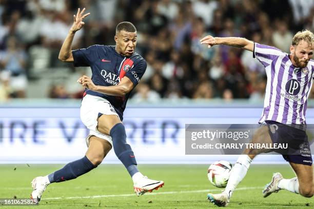 Paris Saint-Germain's French forward Kylian Mbappe shoots the ball past Toulouse's Danish defender Mikkel Desler Puggaard during the French L1...