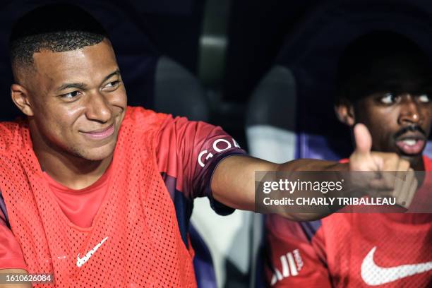 Paris Saint-Germain's French forward Kylian Mbappe gives the thumb-up as he sits on the bench for the start of the French L1 football match between...