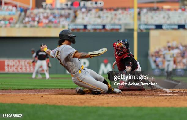 Christian Vazquez of the Minnesota Twins unsuccessfully attempts the tag on Ji Hwan Bae of the Pittsburgh Pirates in the sixth inning at Target Field...