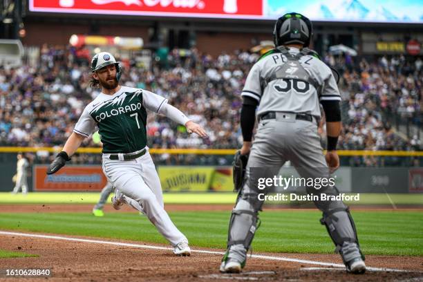 Brendan Rodgers of the Colorado Rockies scores a first inning run as Carlos Perez of the Chicago White Sox looks on at Coors Field on August 19, 2023...