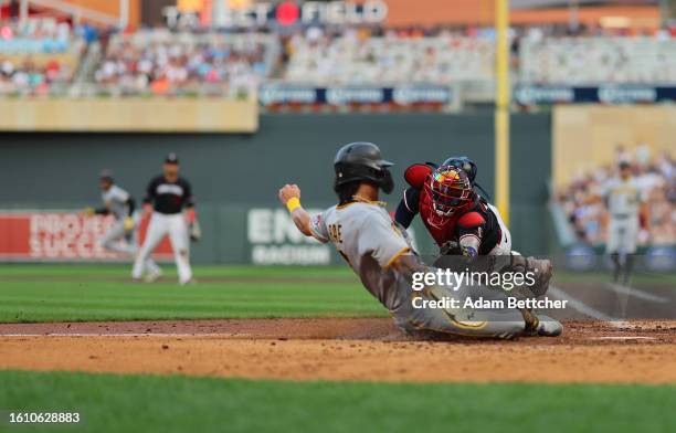 Christian Vazquez of the Minnesota Twins unsuccessfully attempts the tag on Ji Hwan Bae of the Pittsburgh Pirates in the sixth inning at Target Field...