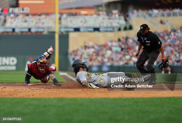 Christian Vazquez of the Minnesota Twins unsuccessfully attempts the tag on Ji Hwan Bae of the Pittsburgh Pirates in the sixth inning at Target Field...