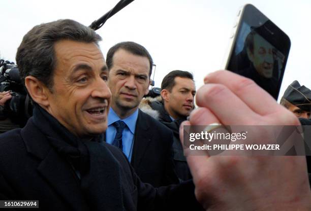 France's President Nicolas Sarkozy is pictured as he shakes hands with people outside the French solar panel maker PhotoWatt in Bourgoin-Jallieu in...